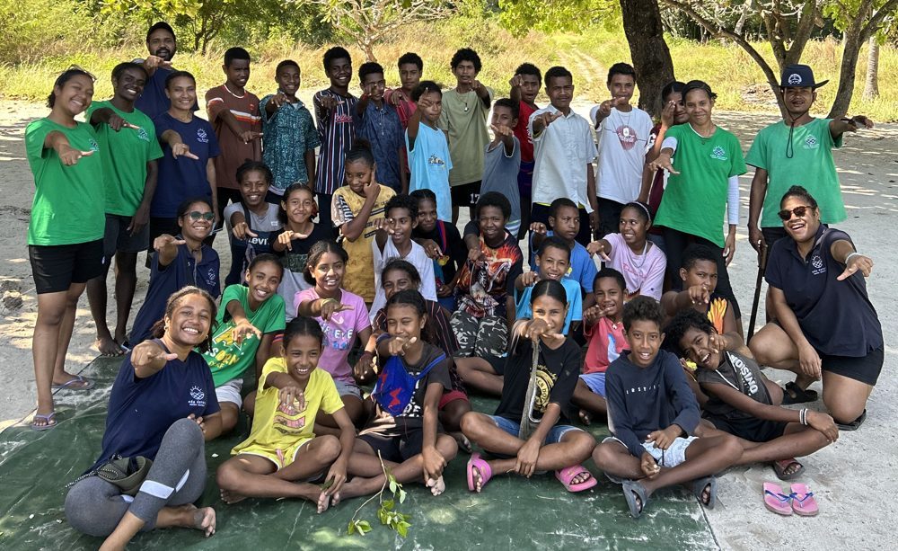 Young EcoExplorers and Eda Davara guides under a tree at Kohua Beach