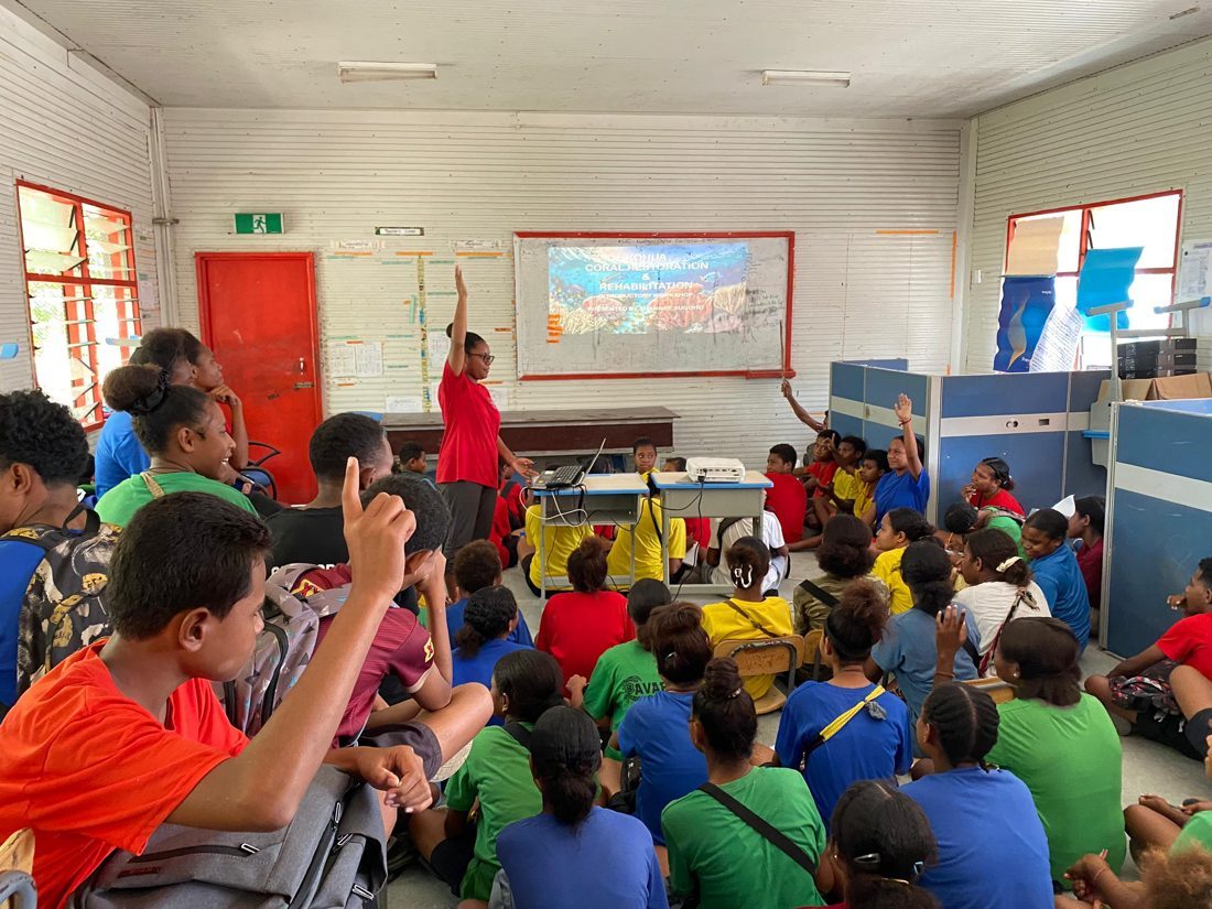 EcoRangers raising their hands during a coral reef workshop at Barakau Primary School