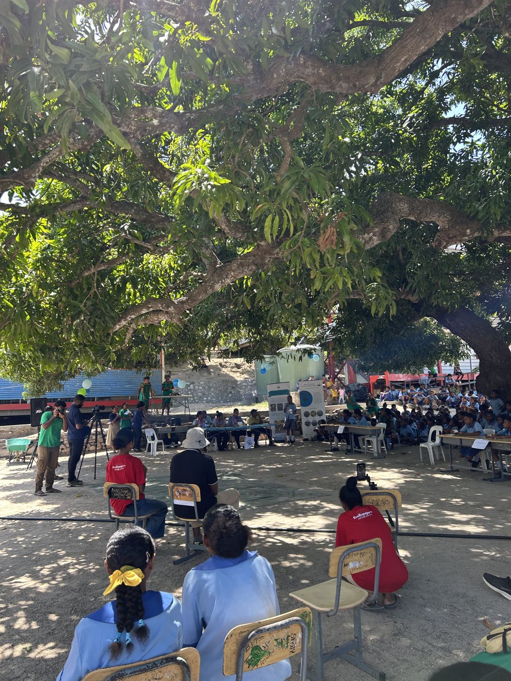 Students and guests gathered under the trees at Barakau Primary School for the debate