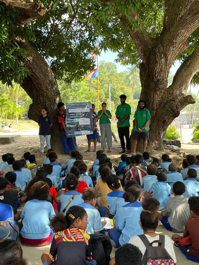 Students gathered under a tree at Kohua for an EcoExplorers awareness session