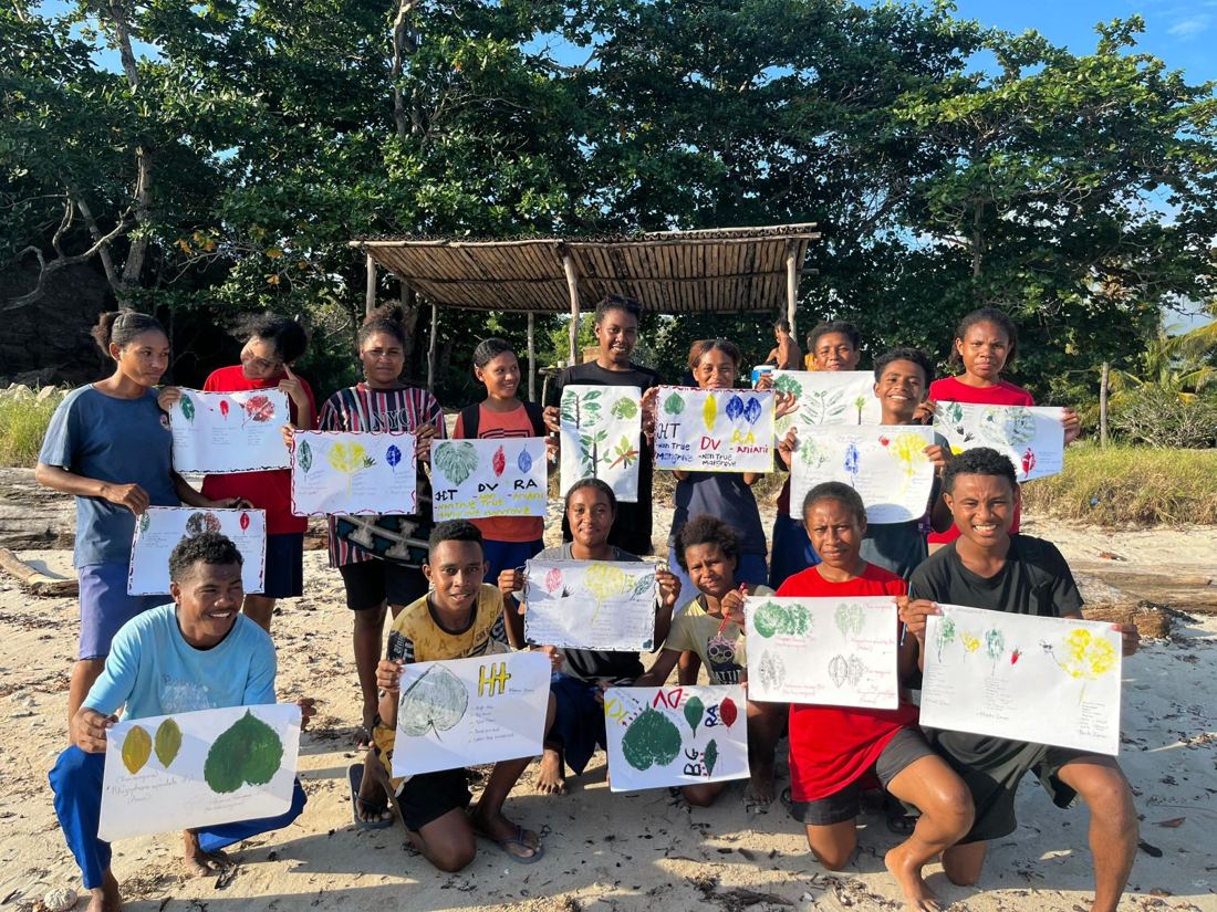 Students on Kohua Beach holding up leaf prints that label true and non-true mangroves