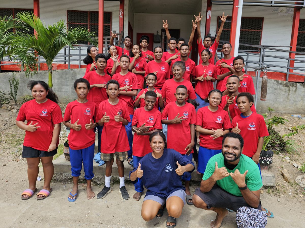 The 2024 EcoRangers in red Eda Davara shirts with team members at Barakau Primary School
