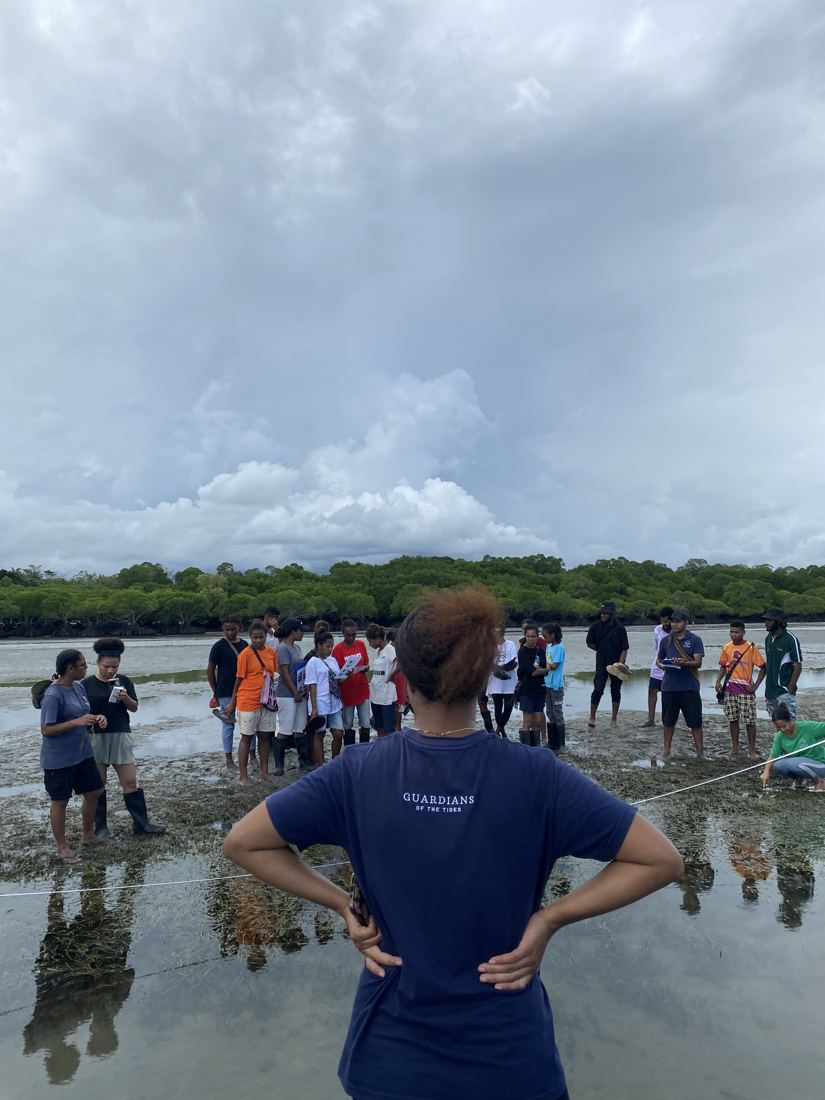 An EcoScholar leading a group of students on the tidal flats