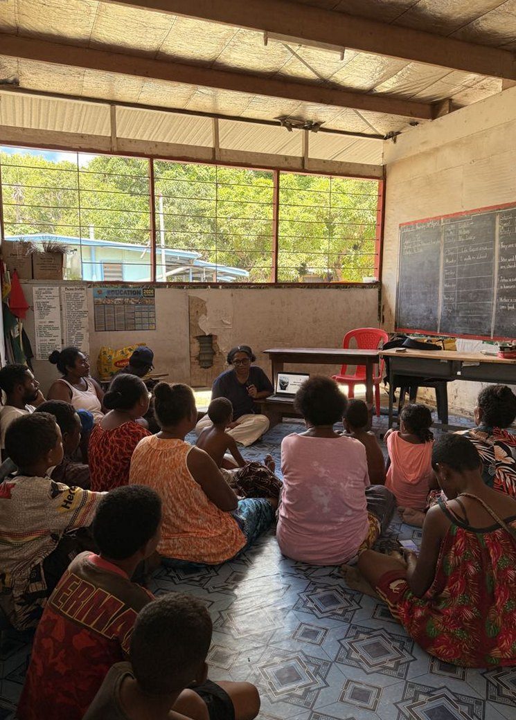 Villagers seated on the floor of a classroom for a mangrove workshop