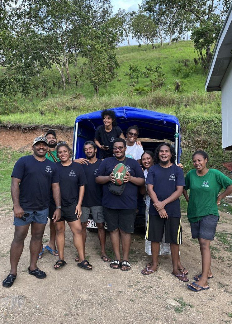 The 2023 Eda Davara team in front of a blue-canopied truck